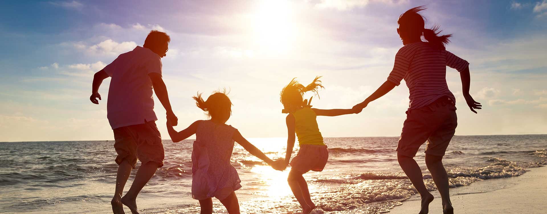 Family on Beach Family of four jumping on the beach during sunset